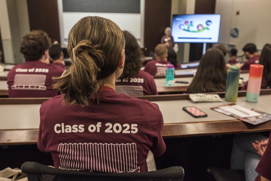 Students listen as Office of Career Services staff speak at the front of a classroom.