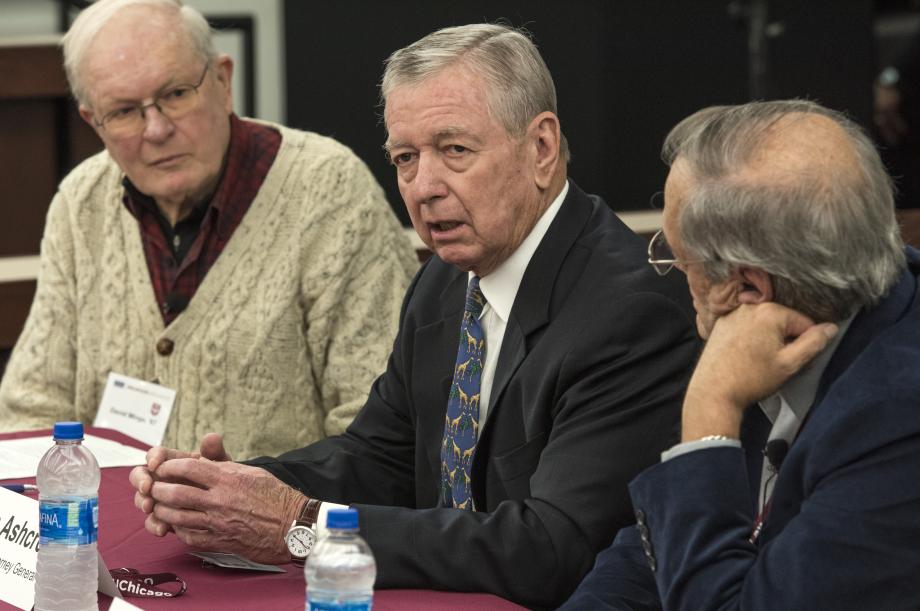 Three alumni sit at a table for a panel