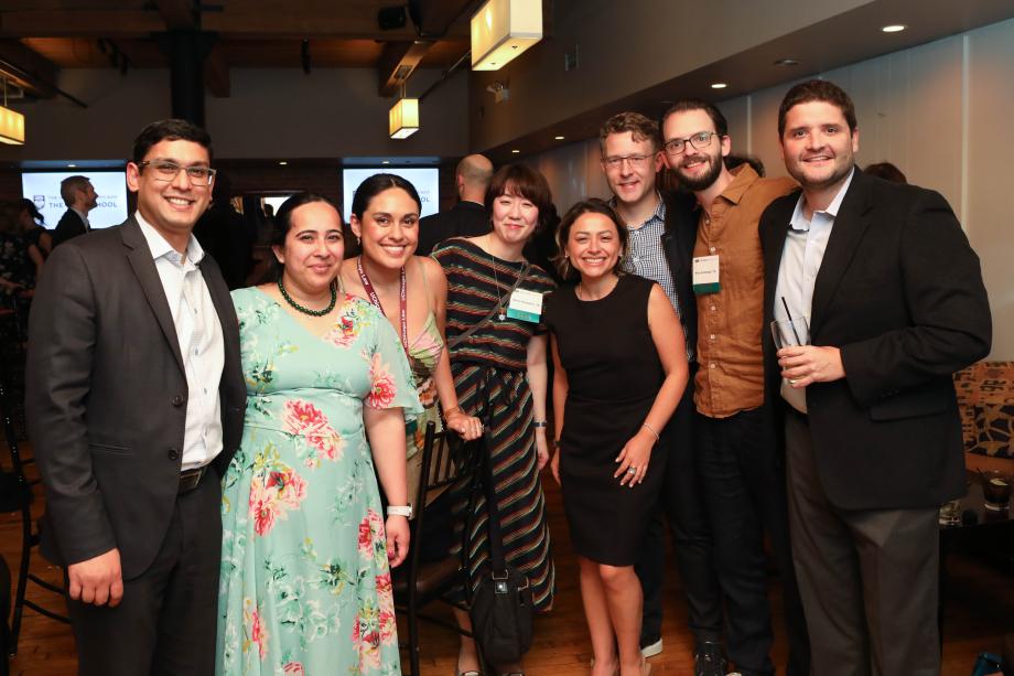 Class Dinners are hosted at various venues across Chicago. A group of well-dressed men and women standing together and posing for a photo.