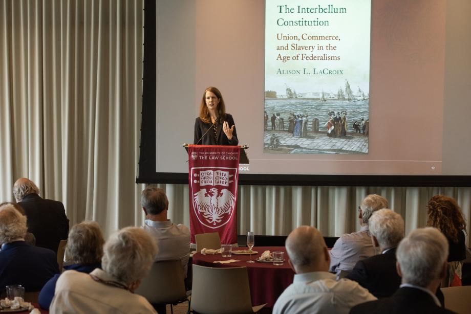 Alison LaCroix, Robert Newton Reid Professor of Law, discusses her new book on US constitutional discourse between 1815 and 1861 at the Loop Luncheon. A woman standing at a lectern addressing a room full of people with a projector screen behind her.