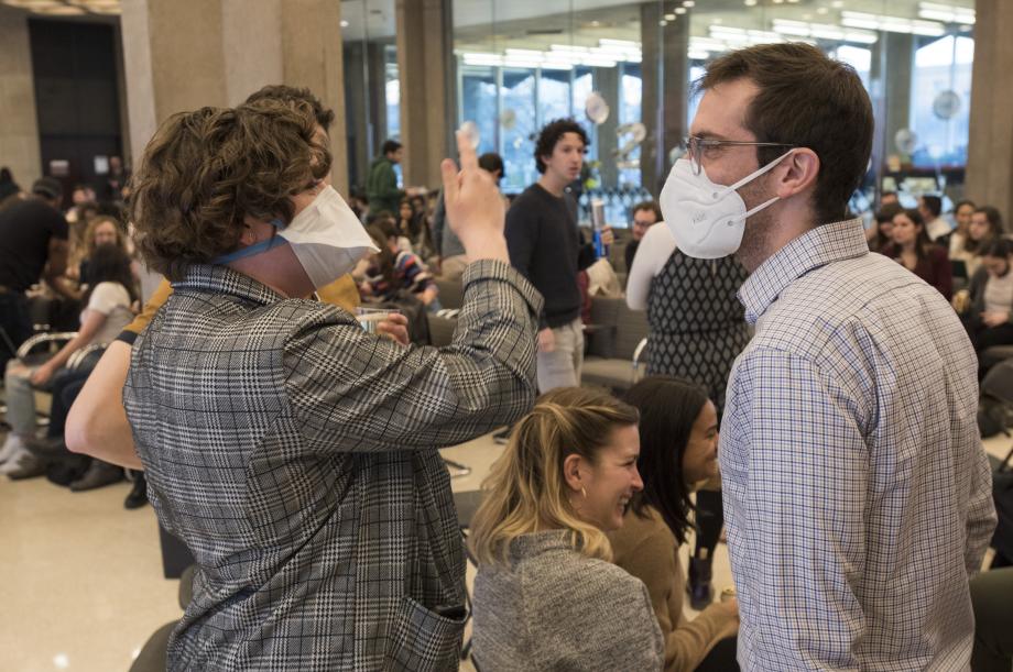 Two masked students chat in the Green Lounge.