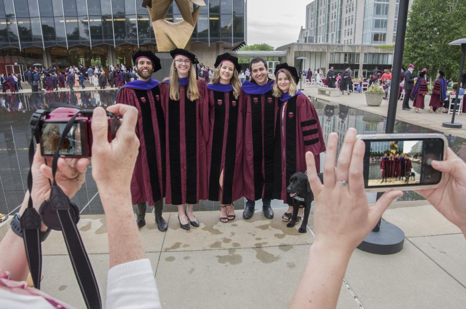 Students pose for photos in front of the reflecting pool back at the Law School.