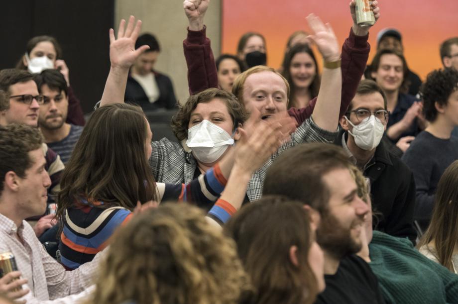 Students clap and put their hands in the air.