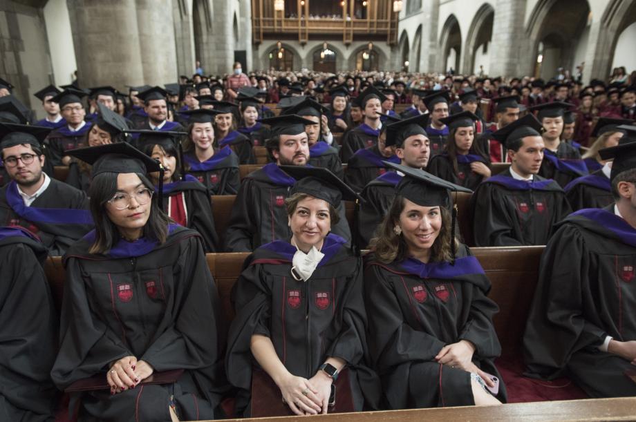 LLM students in their black caps and gowns seated in the pews.