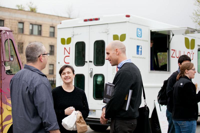 Sean Basinski, right, of the Street Vendor Project, chats with attendees. 