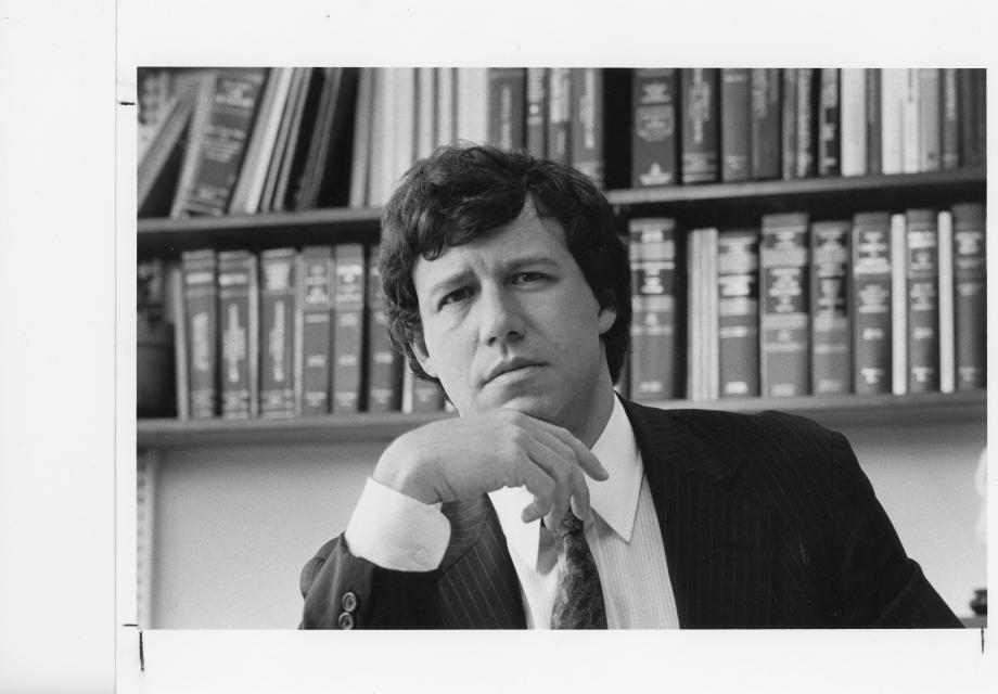 Geoffrey Stone in 1987, the year he became dean of the Law School. Stone, in a suit, looks into the camera with rows of books behind him.