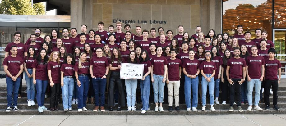 Approximately 80 members of the LLM class of 2024 pose for a class photo holding a sign "LLM Class of 2024."