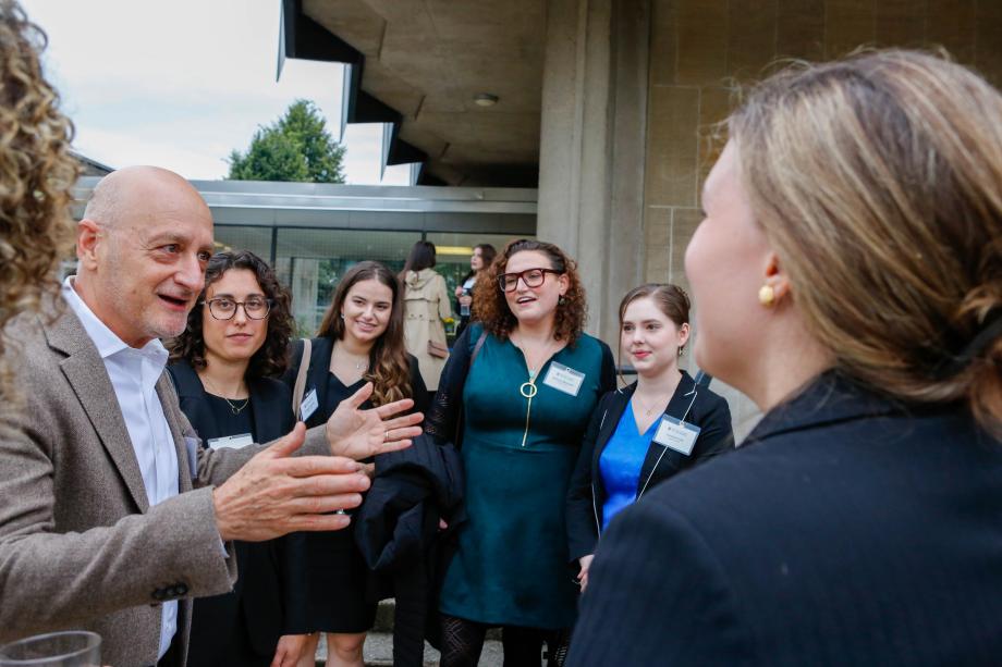 Several students form a circle around Omri Ben-Shahar, who gesticulates as he speaks to them.