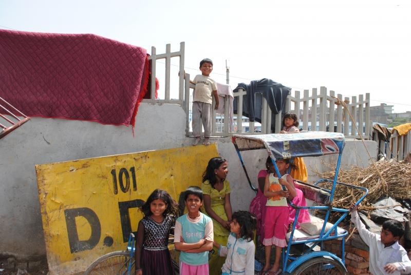 Children from Baljeet Nagar pose on and around a rickshaw. 