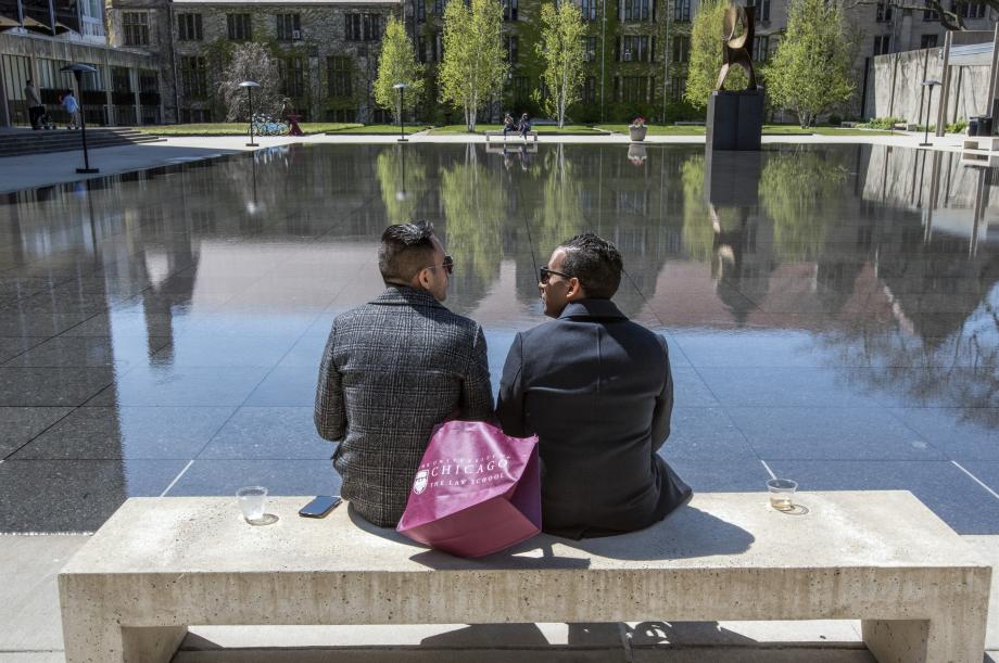 Two alums look out over the reflecting pool.