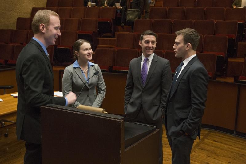 Three of the competitors chat with Jeff Gilson, left, chair of moot court.