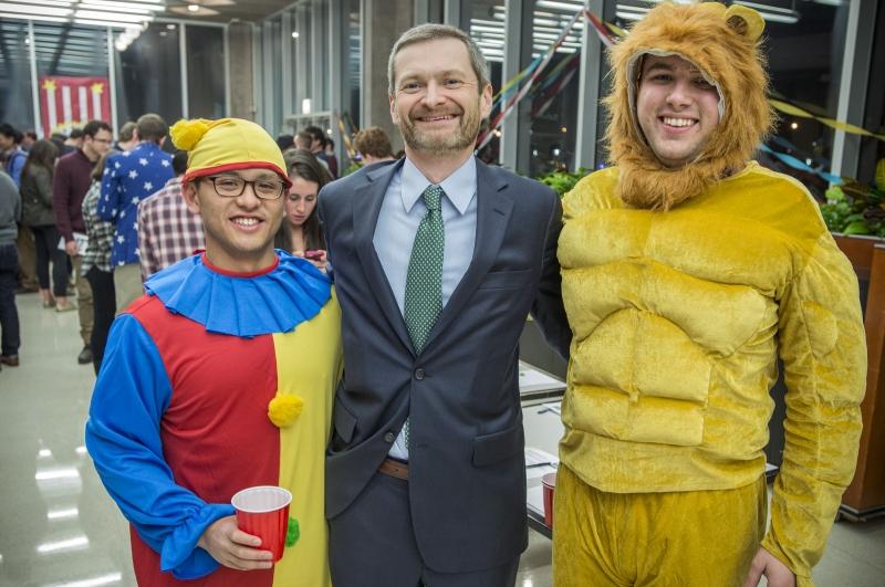 Two costumed students posed with Dean Thomas J. Miles.