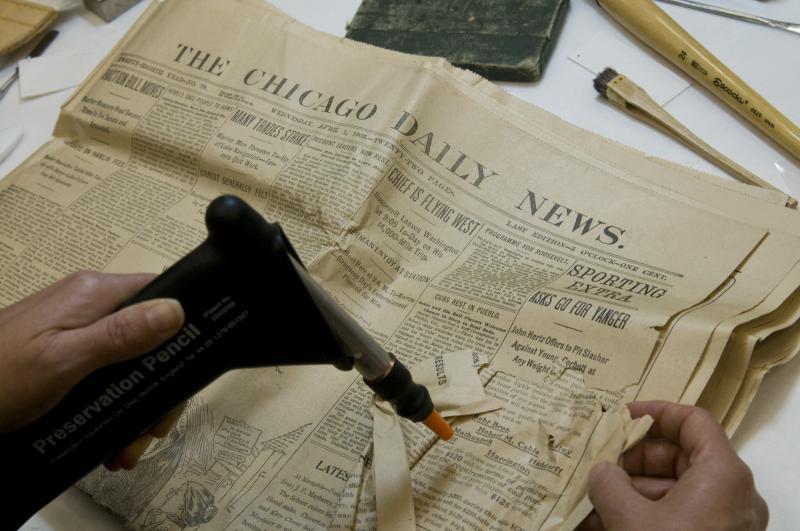 The 1903 box contained many newspapers, now 106 years old, showing the activities surrounding the laying of the cornerstone of the Law School's first long-term home, Stuart Hall. President Teddy Roosevelt attended the event, so it was on the front page of most papers. The papers had varying degrees of damage, and Ann worked to flatten and repair the newspapers. The 1903 box contained many newspapers, now 106 years old, showing the activities surrounding the laying of the cornerstone of the Law School's first long-term home, Stuart Hall. President Teddy Roosevelt attended the event, so it was on the front page of most papers. The papers had varying degrees of damage, and Ann worked to flatten and repair the newspapers.