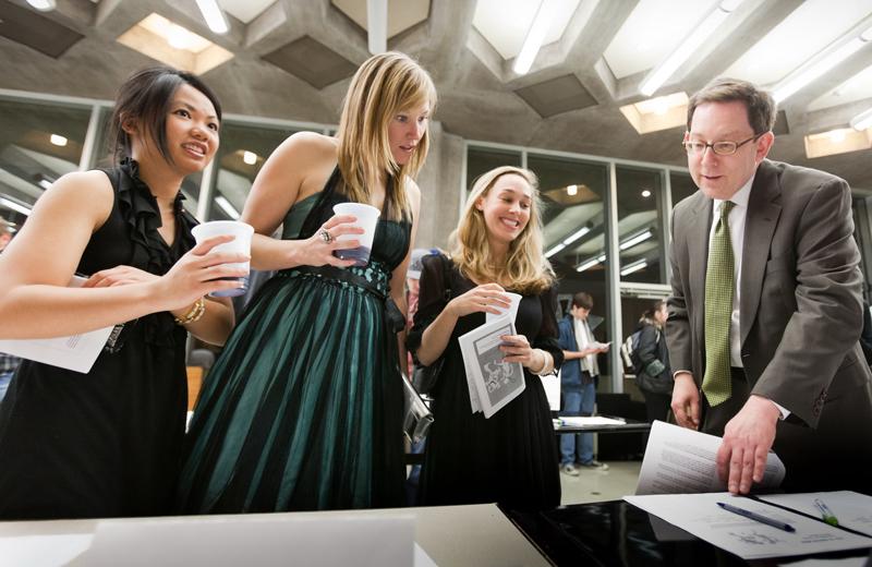 Dean Michael Schill and students look through the silent auction items.