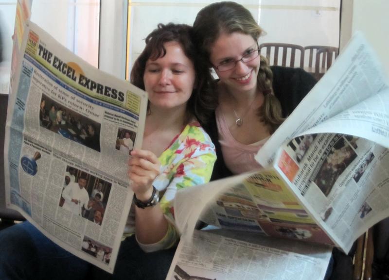 3L Kelly Albinak and 1L Laura Jean Eichten pose with Jammu newspapers
