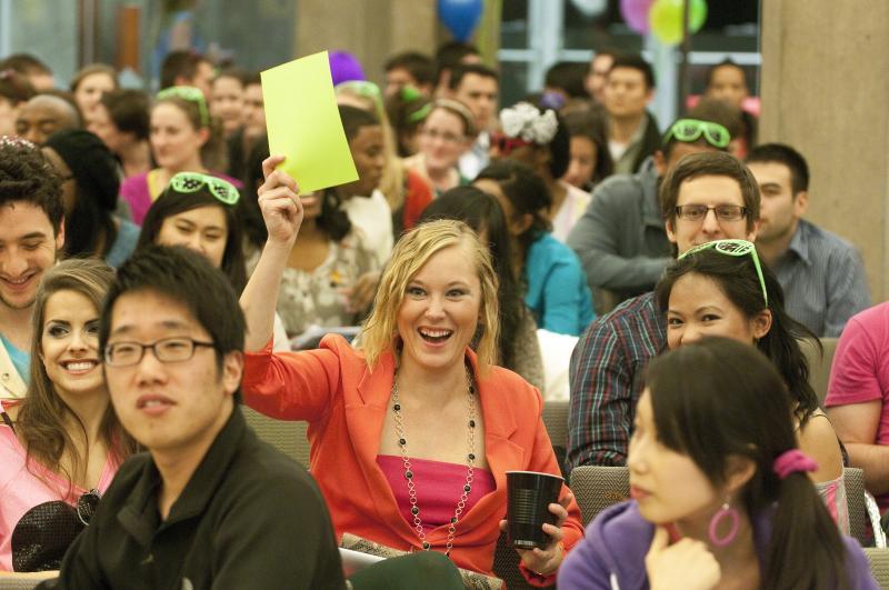 Students held up neon placards to try to claim the winning bid