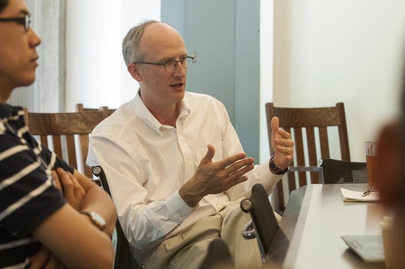 Prof. Todd Henderson listens to a student present his work. 