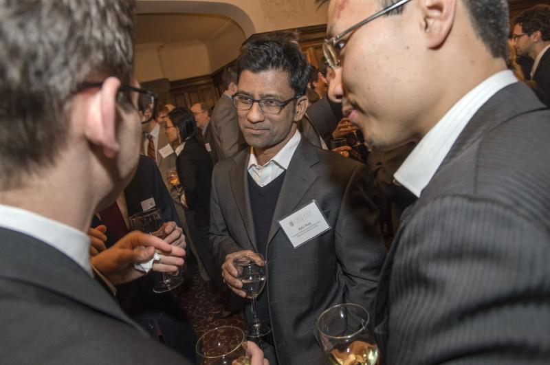 Professor Aziz Huq speaks with students before dinner. 