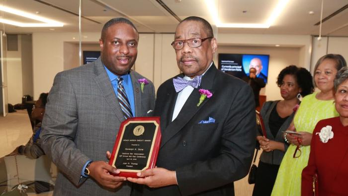 Randolph Stone, on right, holds his award