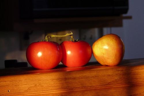photo of two tomatoes and an apple