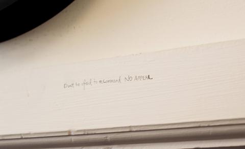 A note, written in pencil above the door, reads: Don't be afraid to recommend no appeal