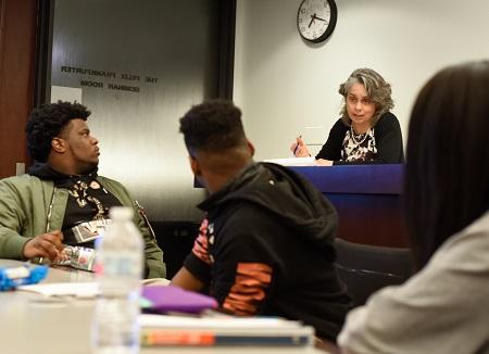 Emily Buss discusses ideas with students, including (from left) Adam Wilson and Kejuan Smith, both Woodlawn students.