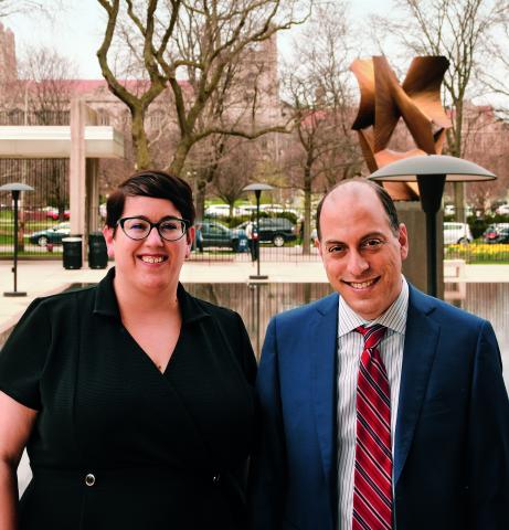 Jamie Luguri and Lior Strahilevitz pose in front of the Pevsner statue in the Law School Reflecting Pool