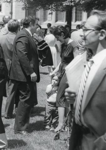 Hutchinson talking to Professor Diane Wood, who has a child next to her. 