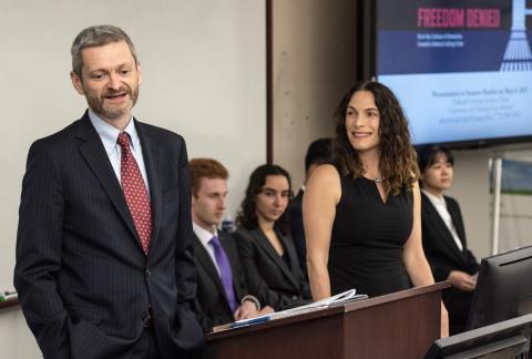 Dean Miles stands at the podium with Professor Siegler.