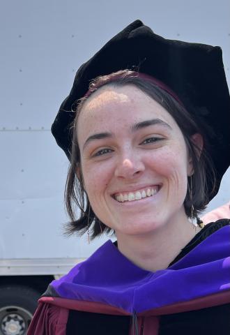 Clare Chiodini in her cap, gown, and hood at graduation