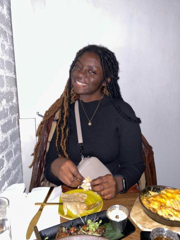 Sanye Sichinga at a table with food in front of her.