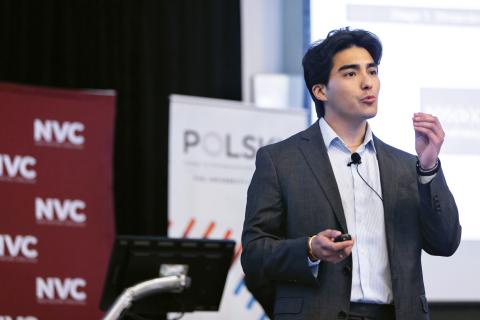 Person in the middle of a speech in front of two signs