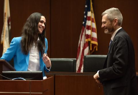 Adriana Robertson interacts with Thomas Miles at the podium.