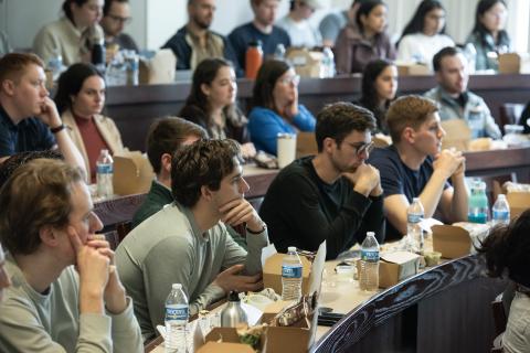 Students sitting in a classroom listening intently to a talk.