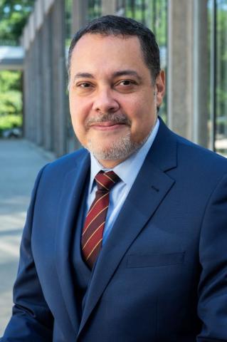 Headshot of a man wearing a dark blue suit