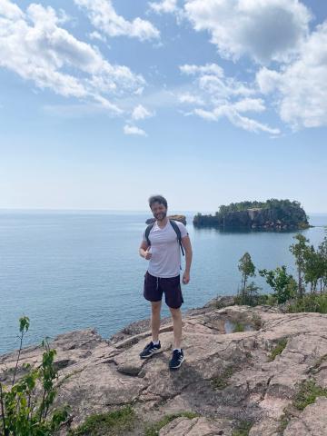 Andrew Kieffer stands on a rocky outcropping overlooking the ocean.