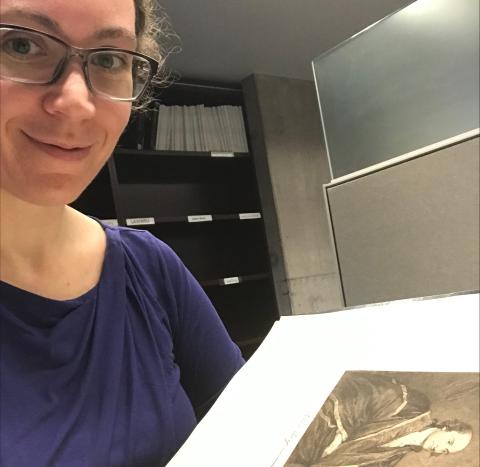 Mary Shelly takes a selfie with a copy of a painted portrait in a book.