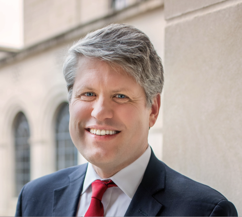 Mike Hilgers wears a dark suit and red tie.