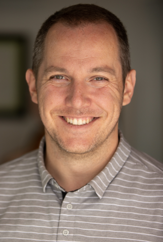 Headshot of a man with blue eyes smiling