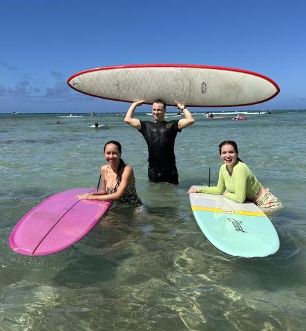 Three individuals with surfboards 