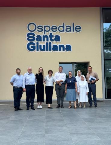Taylor Begin with group, including nuns, in front of hospital in Milan 