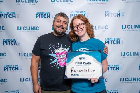 Man and woman standing with first-place award certificate