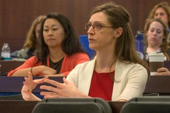 A student gesticulates while seated