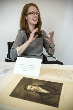 Professor LaCroix gesticulates while she speaks with an old book in the foreground