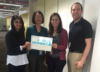 Harris student Salwa Shameem, a country representative, Assistant Professor Claudia Flores and Dylan Cowart hold a a UN Women sign