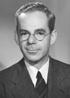 Black and white photograph of Wilber Katz with wire-framed glasses and dark suit and tie.