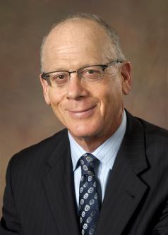 Saul Levmore wears glasses and suit and tie.