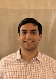 A man with black hair smiling at the camera 