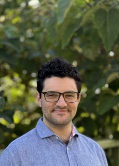 A man wearing glasses faces the camera 
