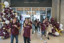 Students mill in the Green Lounge in front of baloons welcoming the Class of 2025